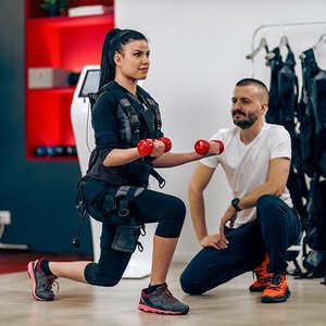 Frau mit Trainer beim EMS-Training
